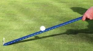 A stimpmeter releases a golf ball onto the green to measure speed